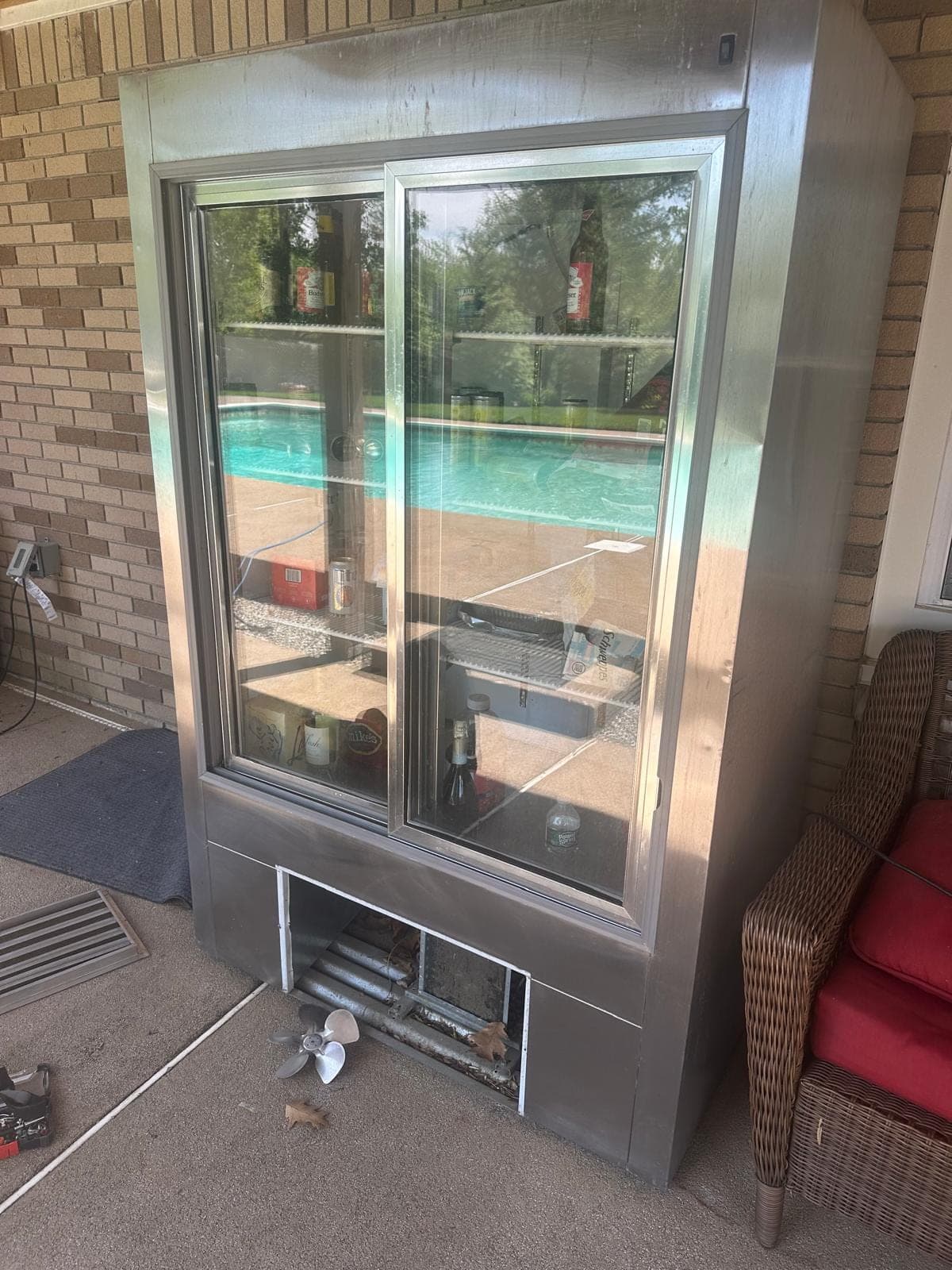 Perlick refrigerator repair in Alexandria, VA — The base panel removed and condenser fan blade pulled for diagnosis