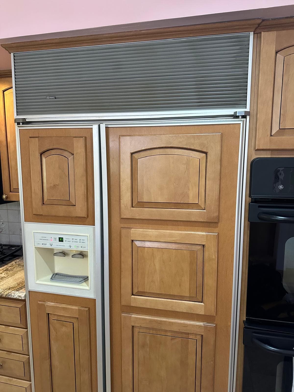 Monogram refrigerator repair in Alexandria, VA — Louvered grille open and panel-ready cabinet doors