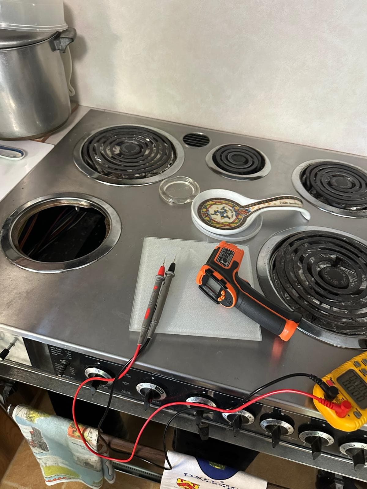 GE range repair in Falls Church, VA — A failed burner element and multimeter connected to the control terminals for diagnosis