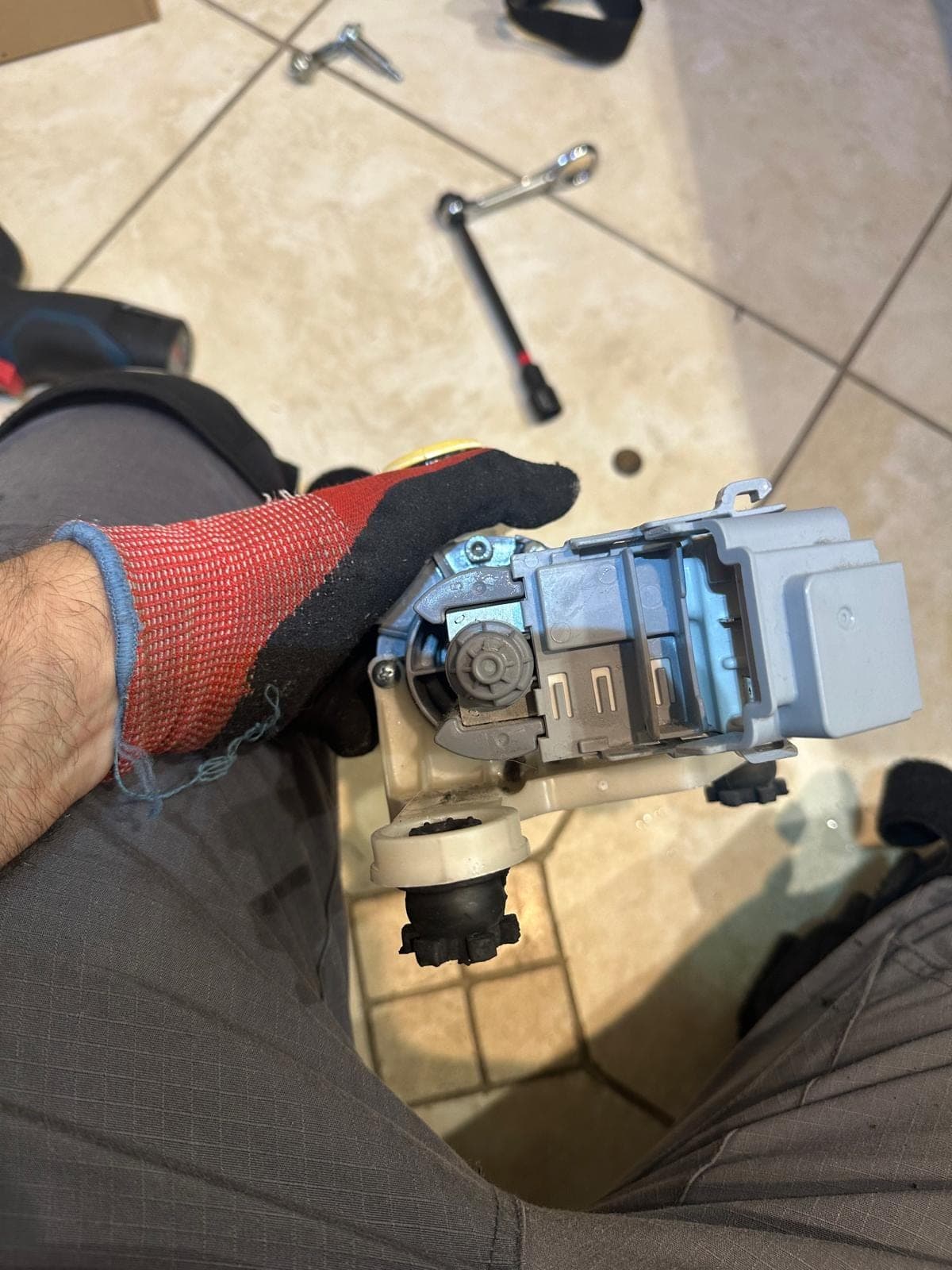 LG washer repair in Alexandria, VA — A failed drain pump motor removed and held for replacement
