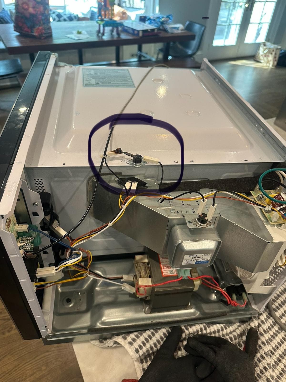 Samsung microwave repair in McLean, VA — The top panel removed, exposing a burned thermal fuse, magnetron, and control board