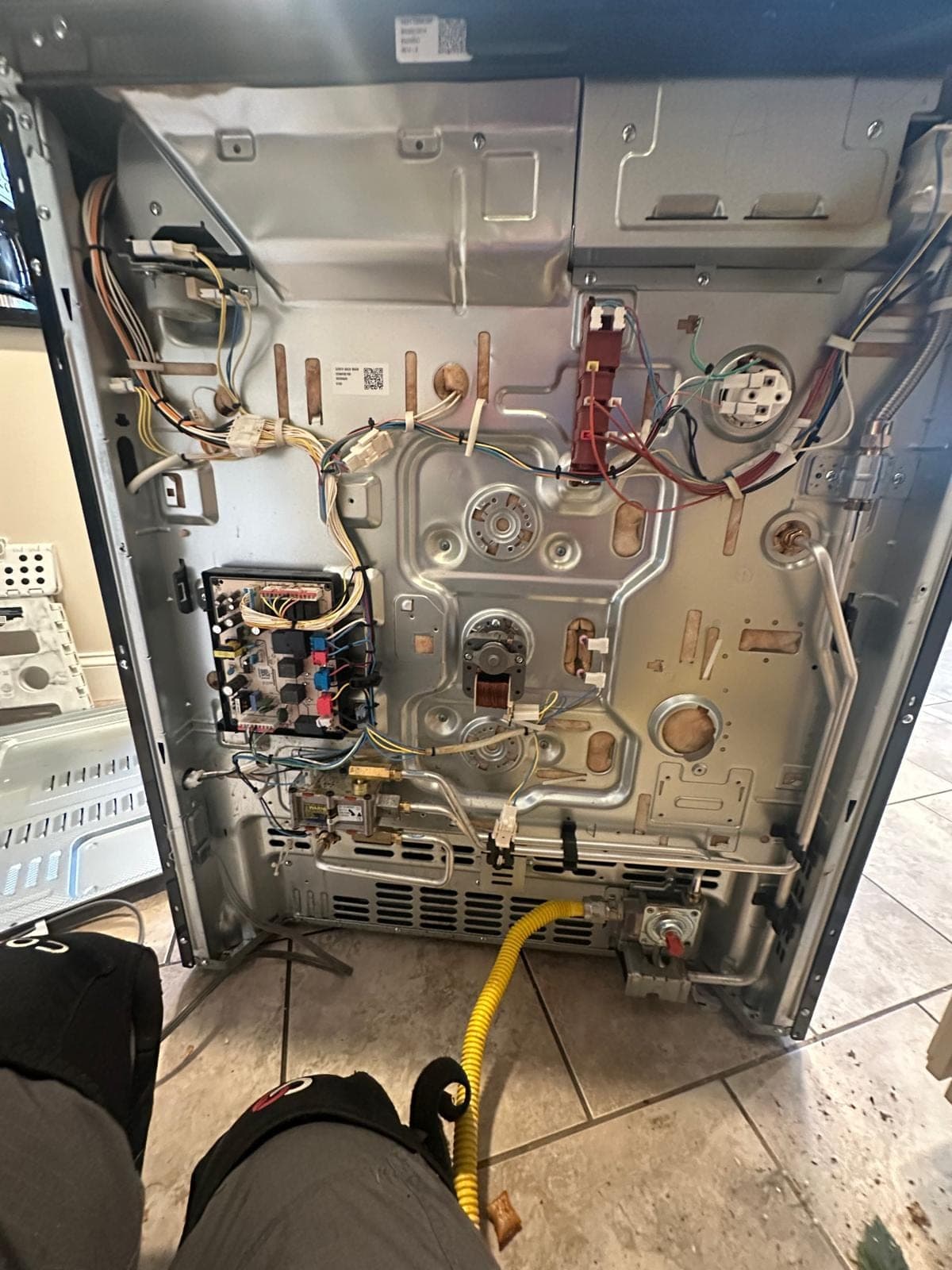 Samsung range repair in Alexandria, VA — The back panel removed, exposing the control board, gas valve, and convection fan motor