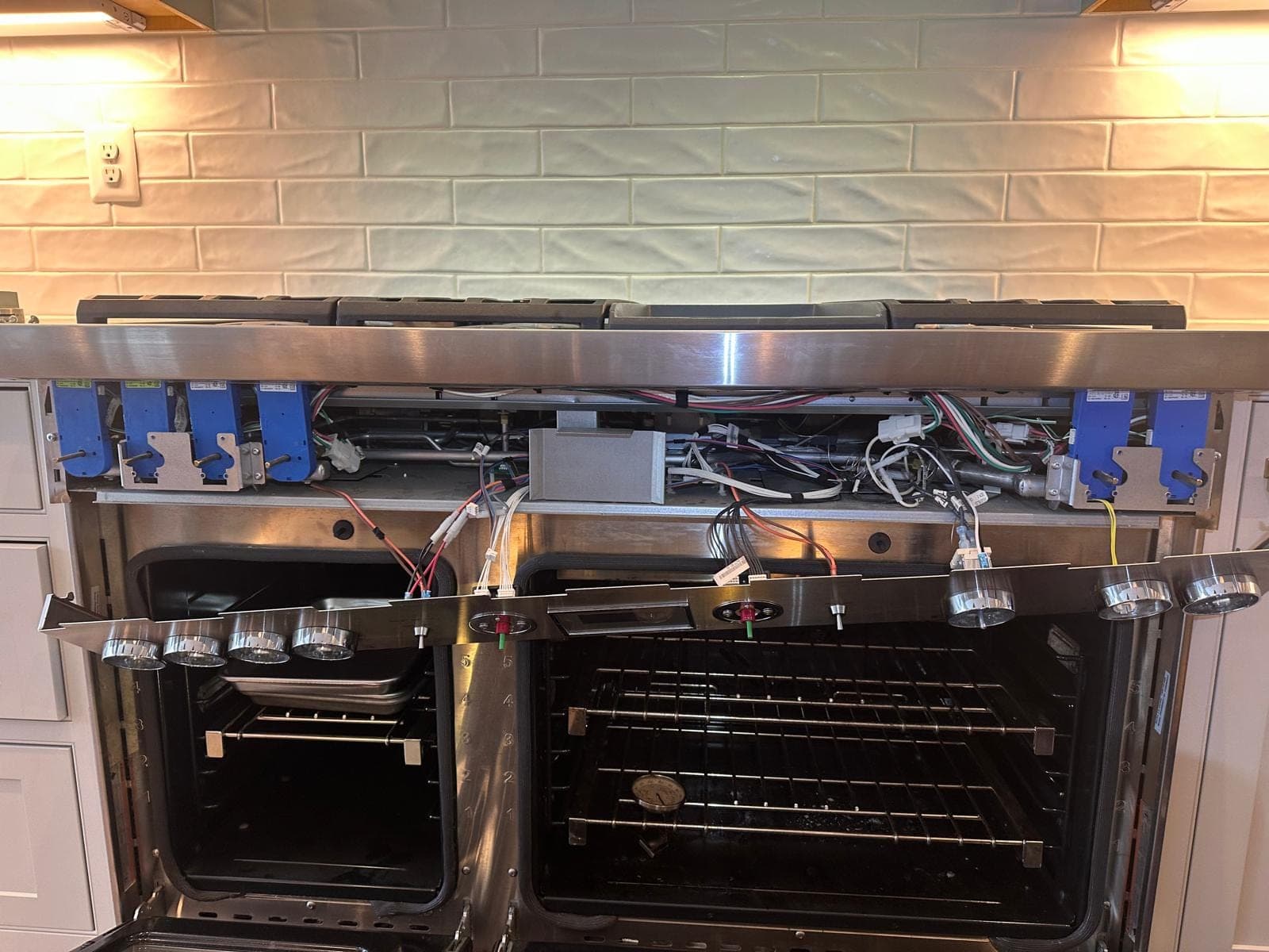 Samsung range repair in Falls Church, VA — The control panel removed, exposing igniter modules and wiring
