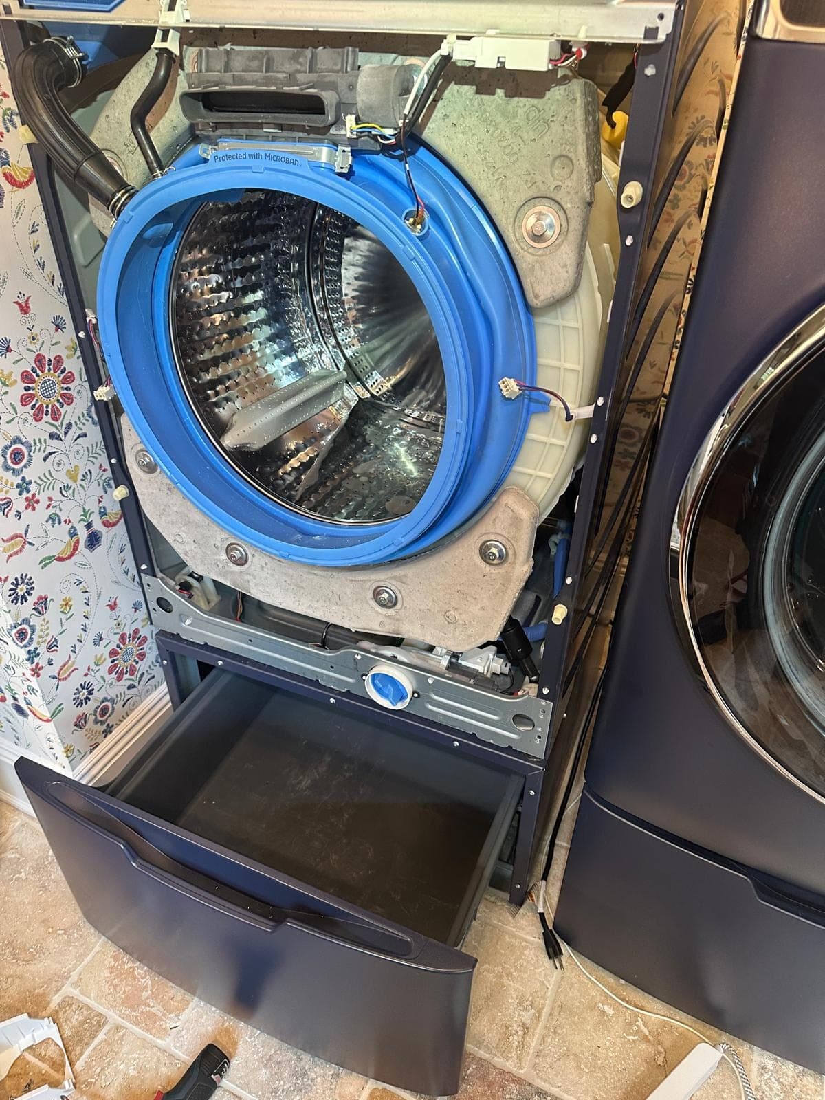 GE washer repair in Falls Church, VA — The front panel removed, exposing the drum, door boot seal, and outer tub