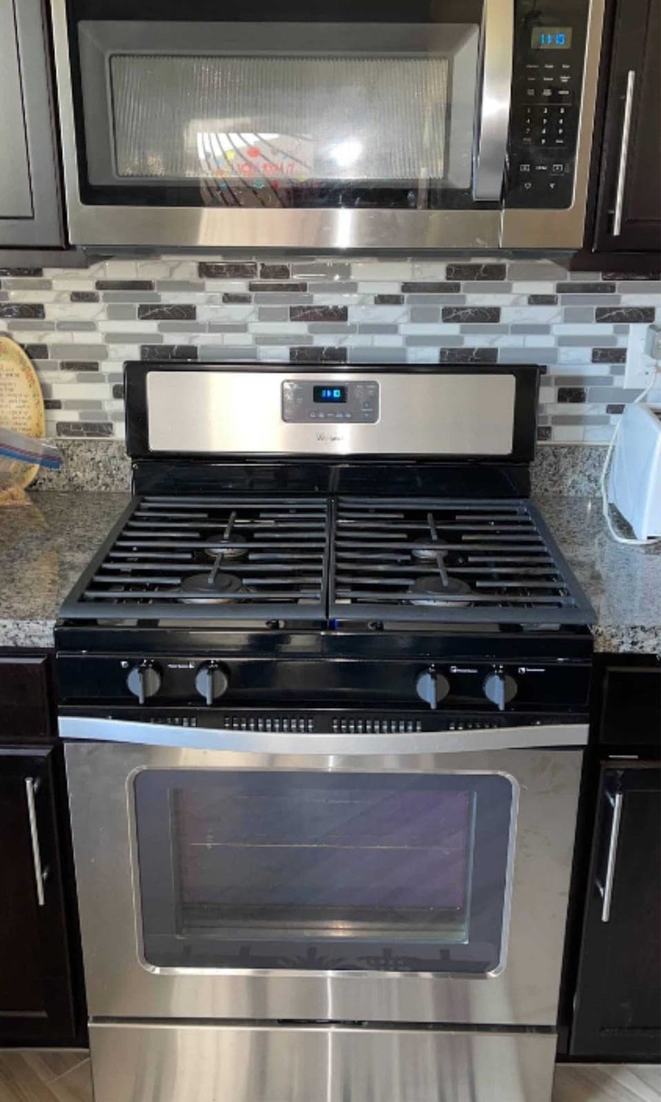 Whirlpool microwave installation in Woodbridge, VA — Our technician installed both units in one visit — connecting the gas line to the range, testing all five burners and the oven igniter, then mounting the microwave above with proper ventilation and secure bracket installation