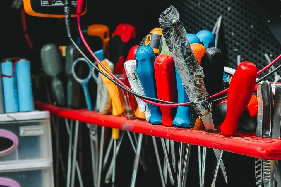 A rack of screwdrivers and hand tools on a workshop bench
