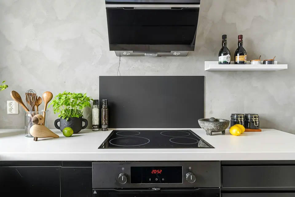 Built-in glass cooktop in a white countertop with a built-in oven below