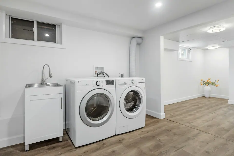 White front-load washer and dryer side by side in a bright laundry room