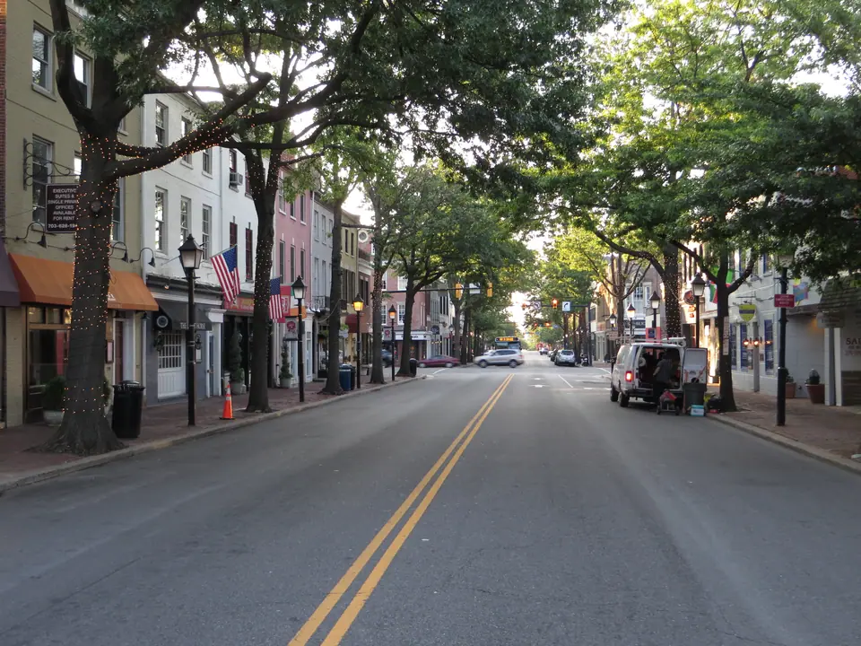 The 700 block of King Street in Old Town Alexandria, Virginia, looking east toward Washington Street, with brick storefronts, street lamps and shade trees