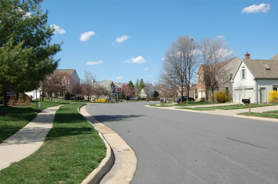 A quiet residential street of single-family homes with lawns and spring blossoms in Ashburn Village, Ashburn, Virginia