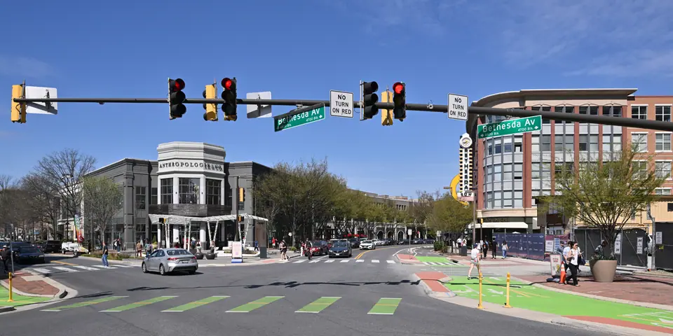 Woodmont Avenue at Bethesda Avenue in downtown Bethesda, Maryland, with the Bethesda Row shops and street trees on an early spring day