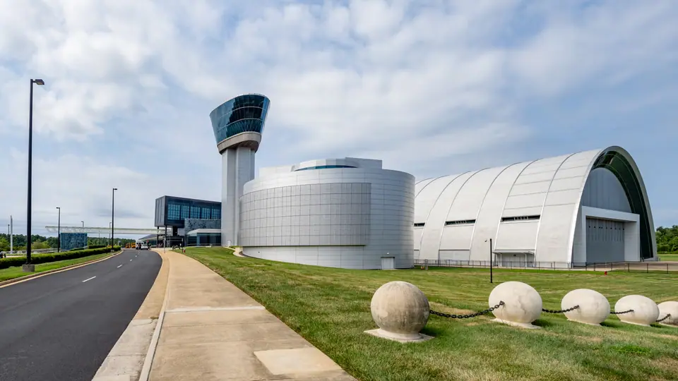 The Steven F. Udvar-Hazy Center of the Smithsonian National Air and Space Museum in Chantilly, Virginia, with its observation tower and curved hangar beside the entrance road