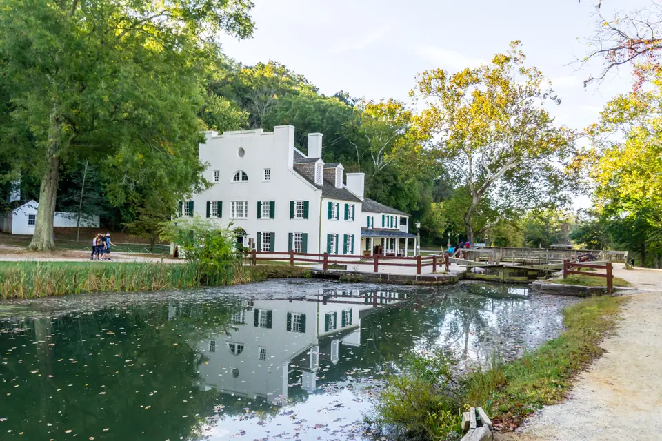 Great Falls Tavern beside the C&O Canal at Great Falls in Potomac, Maryland, reflected in the water on a sunny autumn morning
